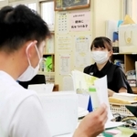 先輩からアドバイスを受けながら授業の準備に取り組む川上美月教諭＝神戸市長田区前原町１、室内小学校（撮影・大山伸一郎）