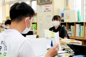 先輩からアドバイスを受けながら授業の準備に取り組む川上美月教諭＝神戸市長田区前原町１、室内小学校（撮影・大山伸一郎）