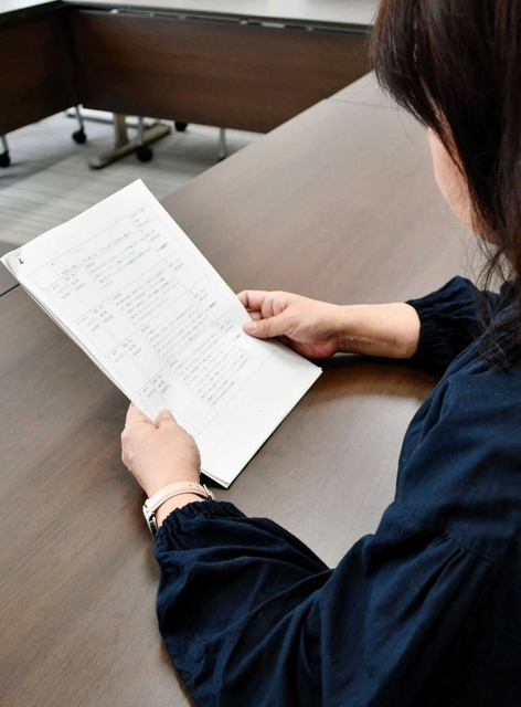 取材に応じる元パート保育士の女性。手元の資料には自身が受けた嫌がらせの内容がまとめられていた＝神戸市内