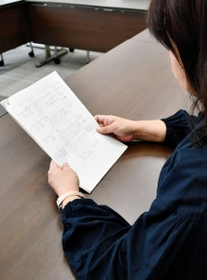取材に応じる元パート保育士の女性。手元の資料には自身が受けた嫌がらせの内容がまとめられていた＝神戸市内