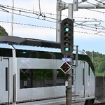 　青２灯を出す信号機と通過するスカイライナー