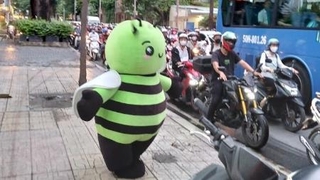 　歩道で踊る日本食スーパーのマスコットキャラクター＝６月９日