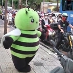 　歩道で踊る日本食スーパーのマスコットキャラクター＝６月９日