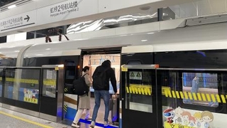 　上海機場連絡線の虹橋空港第２ターミナル駅で、浦東空港行きの列車に乗り込む客＝１２月１３日