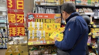 　台北市内のスーパーマーケットでパイナップルケーキの箱を手に取る買い物客＝２月２日