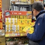 　台北市内のスーパーマーケットでパイナップルケーキの箱を手に取る買い物客＝２月２日