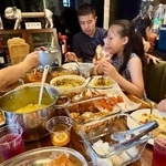 　マレーシアのスランゴール州でオープンハウスに訪れ、料理に舌鼓を打つ来客たち＝３月２８日