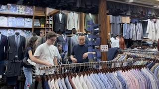 　上海市にある南外灘軽紡面料市場の仕立屋で、スーツの納期を相談する外国人観光客＝５月２日