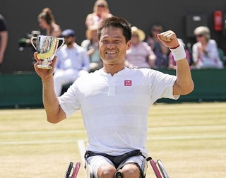 　車いすの部男子シングルスで初優勝し、笑顔でトロフィーを掲げる国枝慎吾選手＝ウィンブルドン（共同）