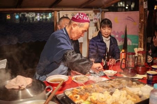 　おでんを取り分ける内田菊治さん＝11月21日、仙台市