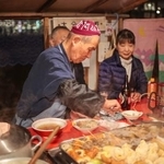 　おでんを取り分ける内田菊治さん＝11月21日、仙台市