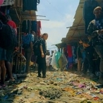 　映画「燃えるドレスを紡いで」の一場面。ケニアの古着市場を訪れた中里唯馬さん（提供写真）