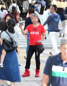「一緒に偽装をなくしましょう」とチラシを配る水谷洋一さん＝５月２６日、神戸市中央区（撮影・辰巳直之）