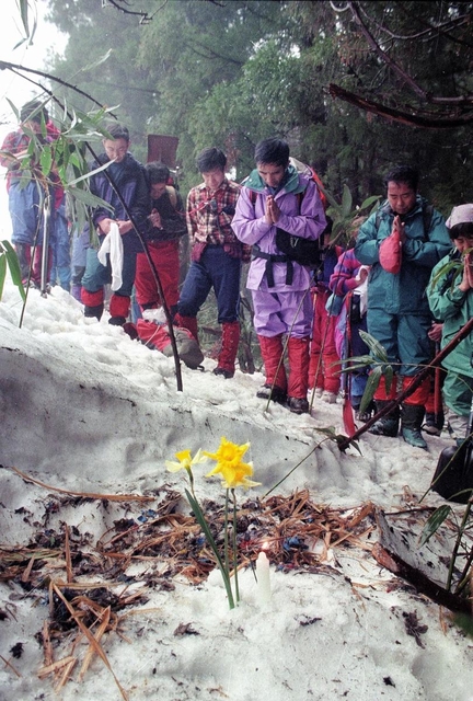 雪崩に巻き込まれた登山者の遺体発見現場で手を合わせる捜索隊員ら＝１９９７年４月６日、養父市関宮、氷ノ山