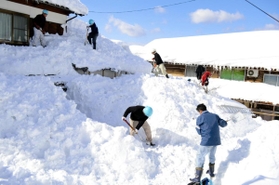 除雪の人手不足を受け、家屋に積もった雪を下ろすボランティアら＝２０１２年２月３日、新温泉町多子