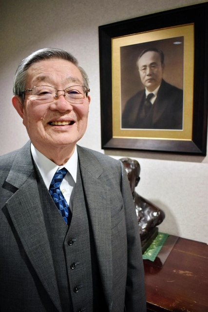 カネボウの創始者で祖父の武藤山治の写真の前で話す武藤治太さん＝大阪市内