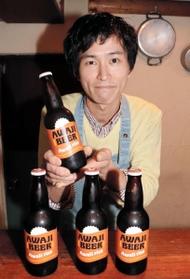 お薦めの淡路島の地ビールを手にする石だたみボーイズリーダーの今井万喜さん＝東灘区田中町３