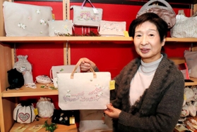 ベトナム刺しゅう入りのバッグを手にする岩村啓子さん＝東灘区岡本５