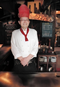 踊りながら肉を焼く店主の寺田孝次さん＝東灘区岡本１