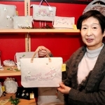 ベトナム刺しゅう入りのバッグを手にする岩村啓子さん＝東灘区岡本５