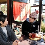 ベトナム紅茶を手に岩村さんと談笑する石だたみボーイズの高岩雄一さん（右）
