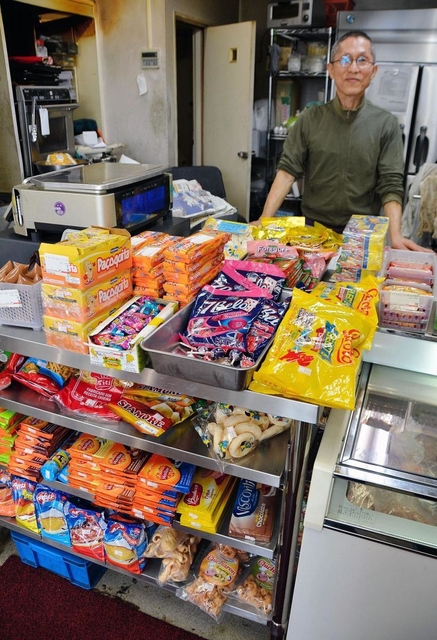 店を経営する竹本悦夫さん。店内には日本のスーパーでは手に入りづらい食品が並ぶ＝神戸市東灘区深江南町４