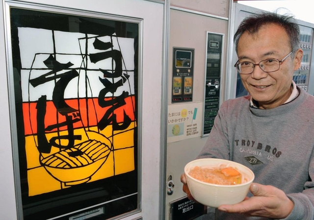うどんとそばを買える自動販売機と石田周三社長＝石田鶏卵