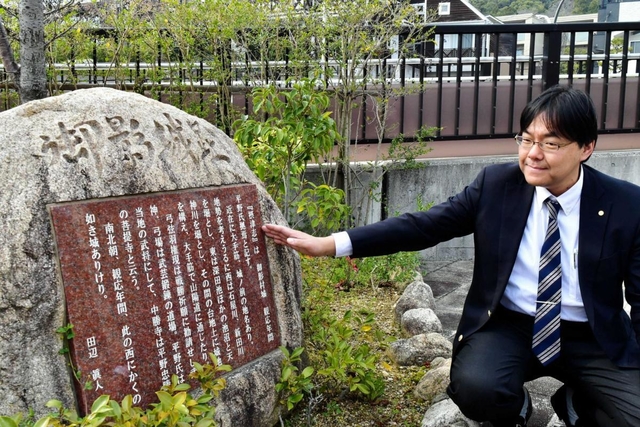 阪急御影駅前にある御影城跡の碑を説明する道谷卓さん＝東灘区御影２