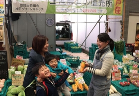 買い物客に野菜の特徴を説明しながら販売する西松由香里さん（左）＝東灘区甲南町３