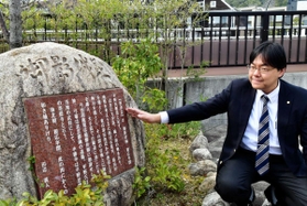 阪急御影駅前にある御影城跡の碑を説明する道谷卓さん＝東灘区御影２