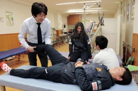ＩＮＡＣ神戸の福田ゆい選手（手前右）と談笑しながらリハビリを行う李潤煥さん（手前左）。中央奥は島袋奈美恵選手＝東灘区住吉本町３