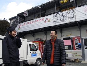 「自分らが頑張んなきゃな」。仮設商店街の前で話す佐々木輝幸さん（右）＝岩手県釜石市鵜住居町