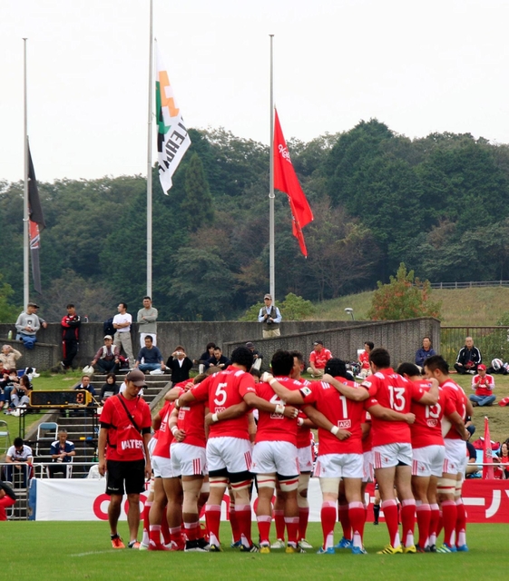 会場には半旗が掲げられ、試合前には神戸製鋼の選手たちが円陣を組んだ＝２２日午後、三重県鈴鹿市の三重交通Ｇスポーツの杜鈴鹿