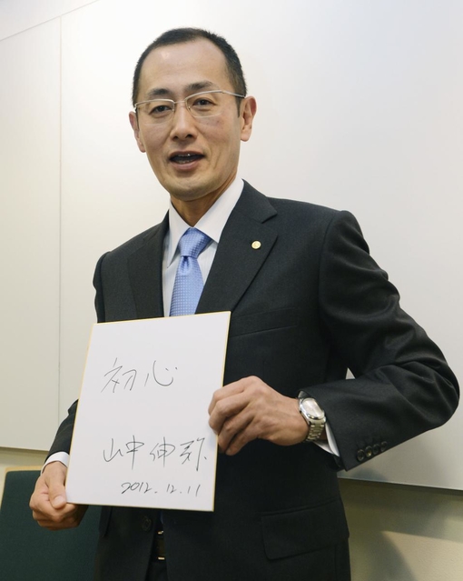 ノーベル医学生理学賞受賞から一夜明け、記者会見で「初心」と書いた色紙を手にする山中伸弥京都大教授＝１１日午前、ストックホルム（共同）