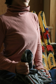 家族のスキー用具を点検しながら、帽子を手にする。「またスキーに行ける、と思って。こんなに早く日常生活に戻ることができ不思議」＝神戸市内（撮影・斎藤雅志）