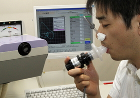息を吐いて肺機能を検査する機器「スパイロメーター」（患者役は医師）＝神戸市中央区楠町７（いずれも撮影・笠原次郎）