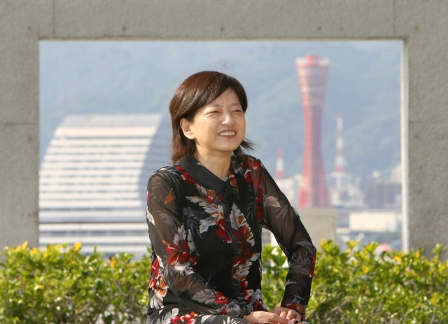 「神戸ほどロマンチックな街はないでしょう？」。銀幕のような景色を背にほほ笑む田中まこさん＝神戸市中央区港島中町１（撮影・大森　武） 