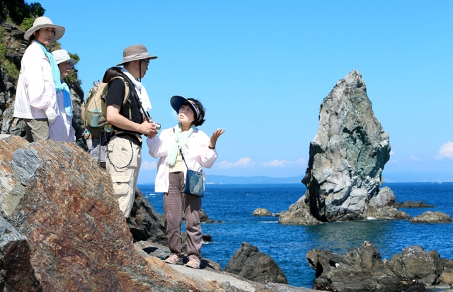 雄々しい上立神岩に歓声を上げる観光客。ぬぼこの会のメンバーが誇らしげに語る＝南あわじ市沼島（撮影・小林良多）
