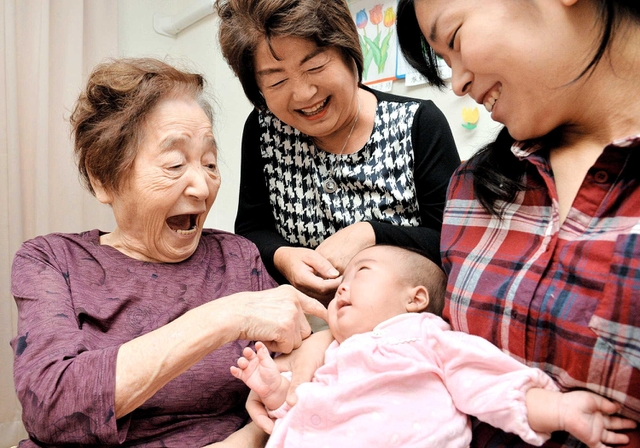 自分の部屋でひ孫らとくつろぐ板東初子さん。お客さんが来る日は気持ちの張りが違う＝高砂市荒井町小松原１（撮影・後藤亮平）