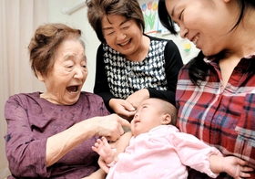 自分の部屋でひ孫らとくつろぐ板東初子さん。お客さんが来る日は気持ちの張りが違う＝高砂市荒井町小松原１（撮影・後藤亮平）