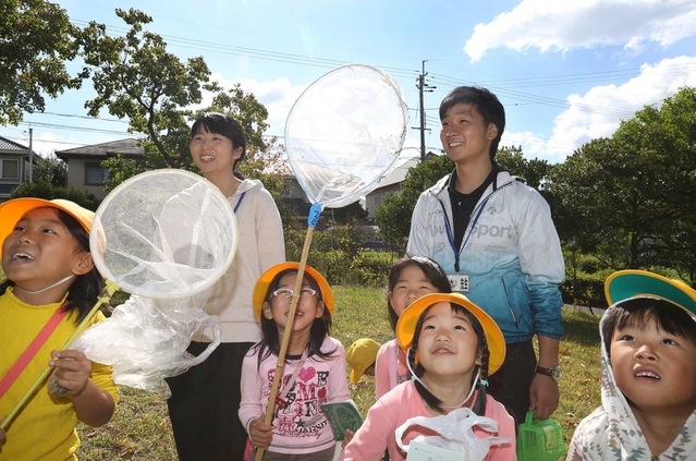 野外授業で１年生と一緒に虫を探す池田菜奈さん（左から２人目）と川井淳平さん＝三田市つつじが丘北２（撮影・大森　武）