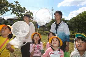 野外授業で１年生と一緒に虫を探す池田菜奈さん（左から２人目）と川井淳平さん＝三田市つつじが丘北２（撮影・大森　武）