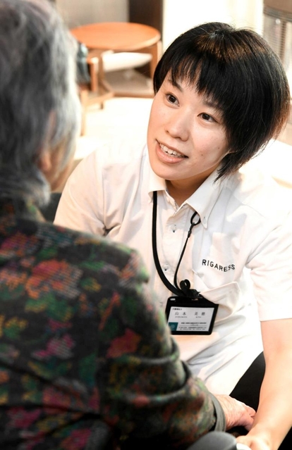 利用者に笑顔で接する介護福祉士の山本美穂さん。「デスカンファレンス」では涙を流し続けた＝豊岡市日高町、リガレッセ（撮影・秋山亮太）