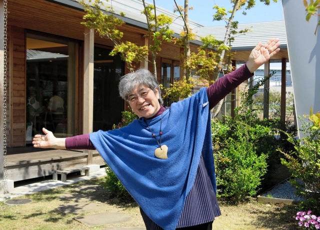 施設の前でポーズを取る秋山正子さん＝東京都江東区、マギーズ東京