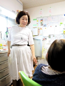 料理の手を止め、入居者と話す豊島あゆみさん＝洲本市下加茂２、「ぬくもりの家　花・花」