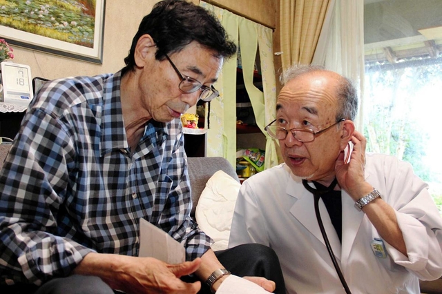 自宅で療養する川島さん（左）に体調を尋ねる徳永進医師＝鳥取市野寺
