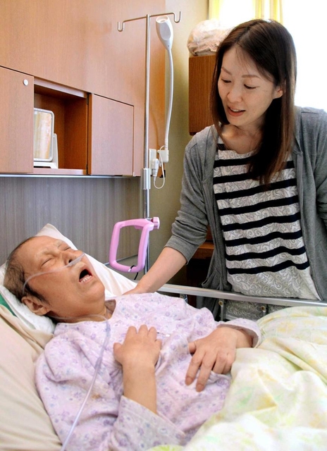 病室で清水千恵子さんの肩に手をやる長女香織さん＝６月１８日、神戸市東灘区