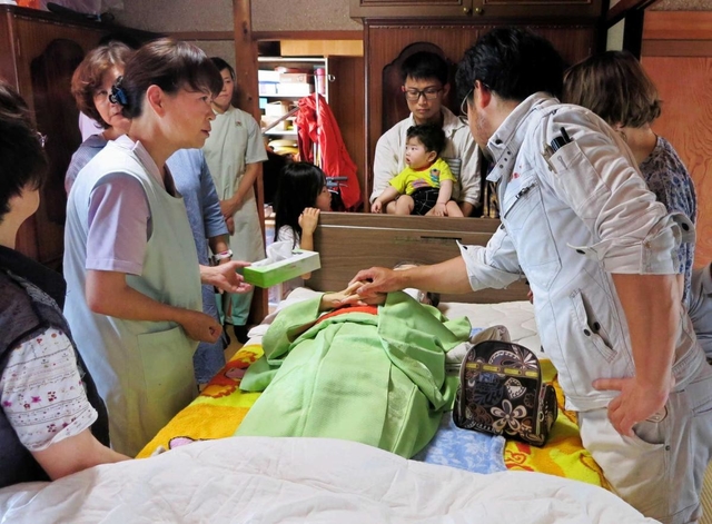 自宅で亡くなった廣尾すみゑさんを囲む家族と友人たち＝小野市内