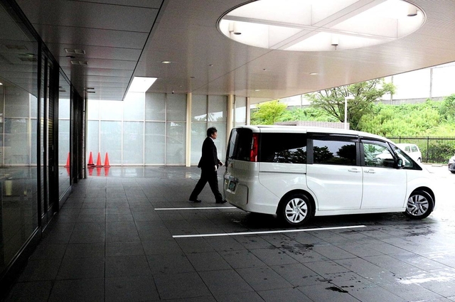 女性の遺体を乗せたワンボックスカー。雨の中、静かに到着した＝尼崎市