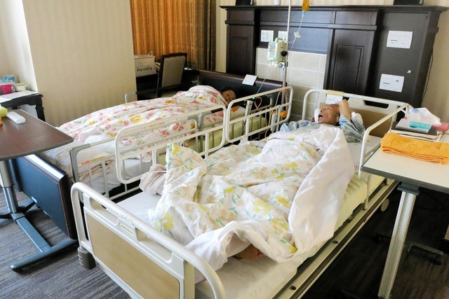 病室で並んで過ごす金森英彦さん（右）と克子さん夫婦＝芦屋市